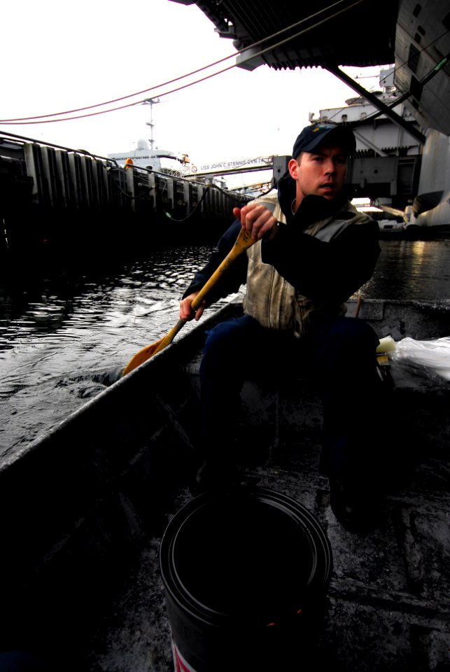 US Navy 100106-N-2475A-262 Boatswain's Mate 1st Class Pete Johnson, from Stanwood, Wash., paddles a punt boat alongside the Nimitz-class aircraft carrier USS John C. Stennis (CVN 74)