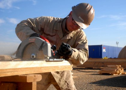 US Navy 100106-N-9564W-238 Builder Constructionman Dennis Dardono cuts wood for the construction of a Southwest Asia hut in the expansion area of Camp Leatherneck
