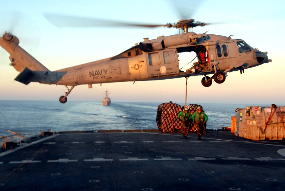 US Navy 100114-N-2600H-119 ailors aboard the Military Sealift Command fast combat support ship USNS Bridge (T-AOE 10) attach cargo to an MH-60S Sea Hawk