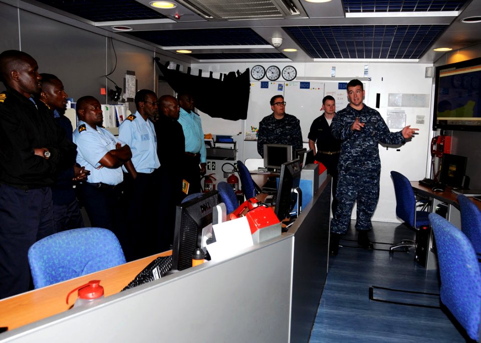 US Navy 100107-N-1429M-003 Information Systems Technician 1st Class Jeremy Katzenstein explains the Automatic Identification System and how it improves maritime domain awareness to the APS international staff