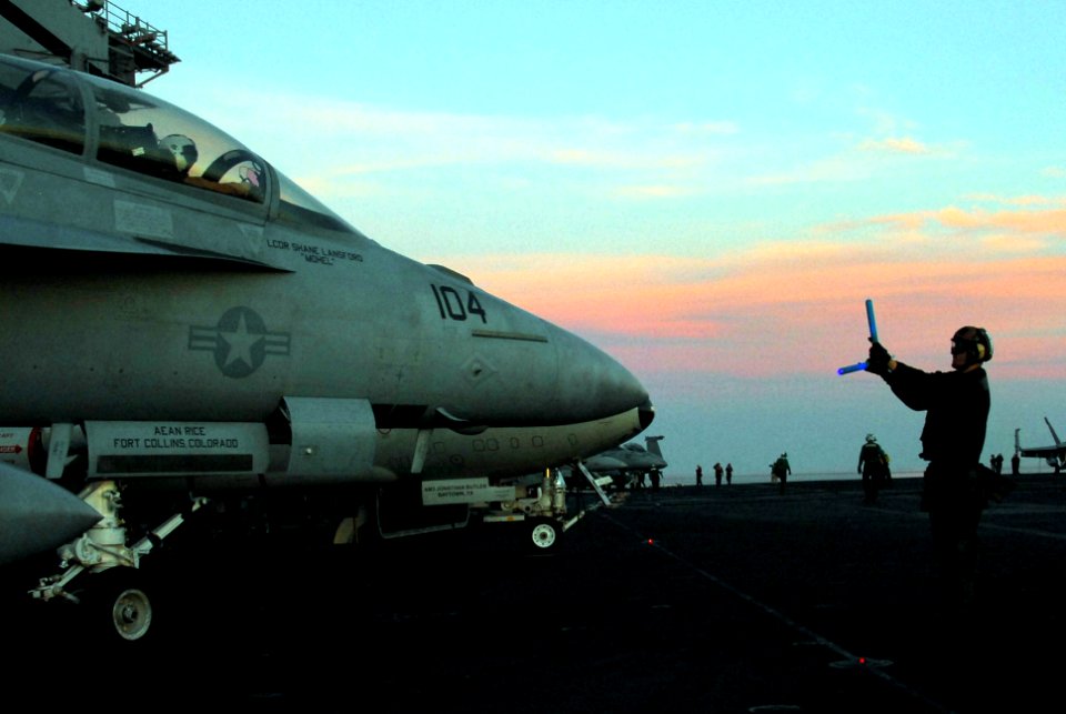 US Navy 100114-N-3589B-058 Aviation Electrician's Mate Airman Michael McGehee assigned to the Black Aces of Strike Fighter Squadron (VFA) 41 directs a