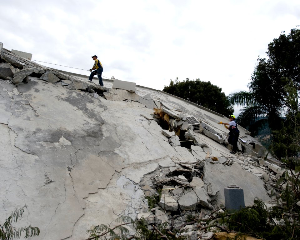 US Navy 100114-N-6266K-005 Members of Fairfax County Urban Search and Rescue scale a collapsed section of the Hotel Montana in Port-au-Prince, Haiti during a search for survivors of a 7.0 magnitude earthquake