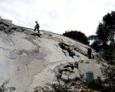US Navy 100114-N-6266K-005 Members of Fairfax County Urban Search and Rescue scale a collapsed section of the Hotel Montana in Port-au-Prince, Haiti during a search for survivors of a 7.0 magnitude earthquake