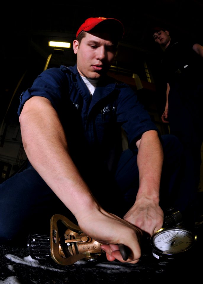 US Navy 100115-N-1261P-021 Damage Controlman 3rd Class Bryce Brittain makes preparations on a vari-nozzle for a hangar bay aqueous film forming foam (AFFF)