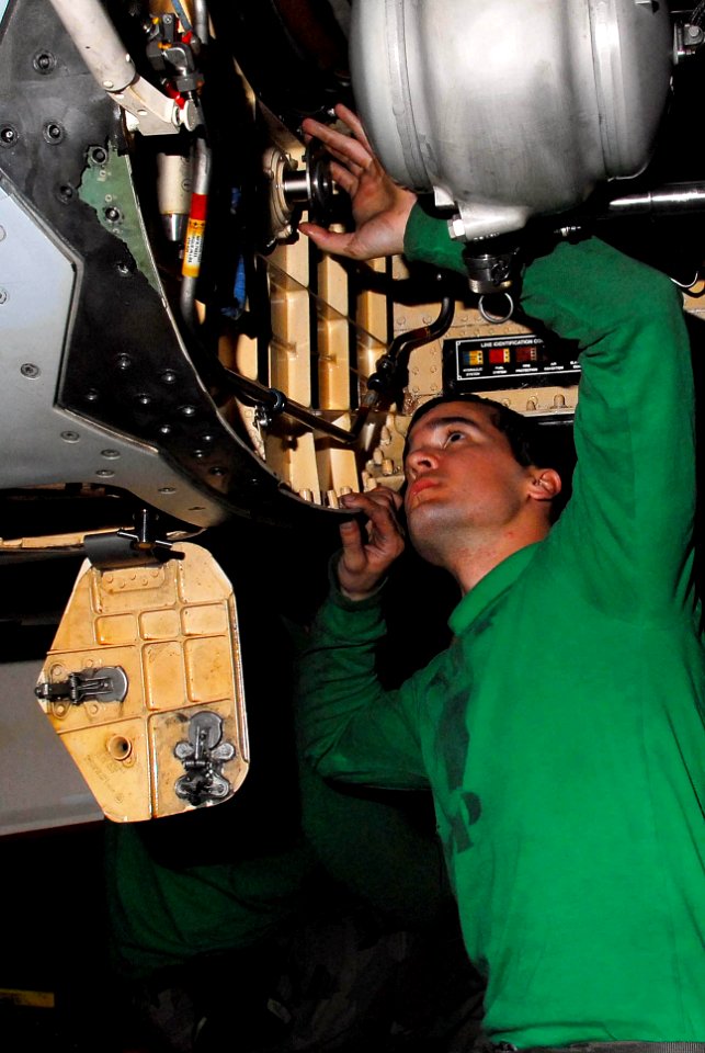 US Navy 100110-N-3327M-162 Aviation Machinist's Mate 3rd Class Jose Rogue performs maintenance on an F-A-18F Super Hornet