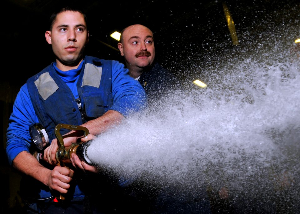 US Navy 100115-N-1261P-017 Aviation Boatswain's Mate (Handling) Freddy Vigilmartinez learns from Chief Damage Controlman Samuel Cavanaugh the proper