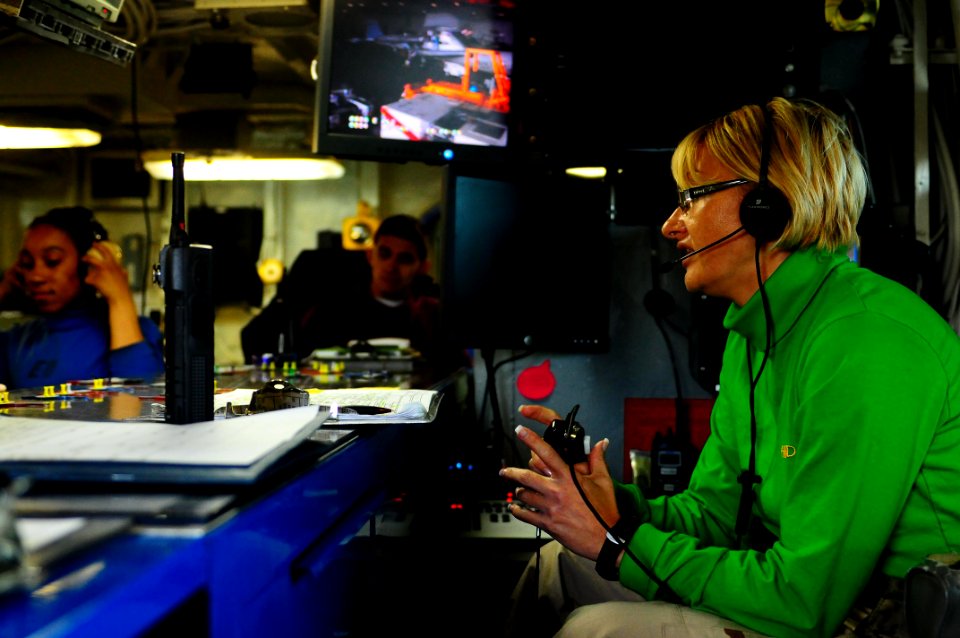 US Navy 100112-N-7939W-005 Lt. Regina Rogers coordinates aircraft movement aboard the aircraft carrier USS Nimitz (CVN 68). Rogers is the first female flight operations handler aboard Nimitz