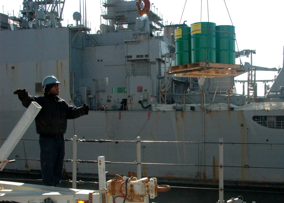 US Navy 100113-N-9806M-005 Boatswain's Mate 3rd Class Jonathan McNeil directs the loading of supplies aboard the amphibious dock landing ship USS Fort McHenry (LSD 43)
