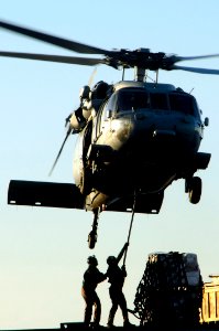 US Navy 100114-N-3038W-589 Crew members aboard the attach a cargo pendant to an MH-60S Sea Hawk helicopter assigned to the Wildcards of Helicopter Sea Combat Squadron (HSC) 23
