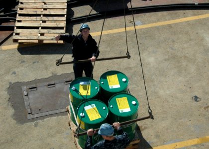 US Navy 100113-N-9806M-032 Boatswain's Mate 3rd Class Sean Church and Seaman Michael Simko direct the loading of supplies aboard the amphibious dock landing ship USS Fort McHenry (LSD 43)