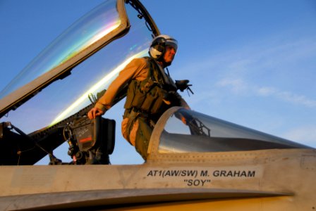 US Navy 100114-N-3327M-127 Cmdr. William Shoemaker, commanding officer of the Warhawks of Strike Fighter Squadron (VFA) 97, climbs into the cockpit of an F-A-18C Hornet aboard the aircraft carrier USS Nimitz (CVN 68)