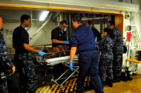 US Navy 100116-N-4774B-916 Aboard USS Carl Vinson (CVN 70) medical team members transport an injured Haitian male for treatment aboard the nuclear-powered aircraft carrier
