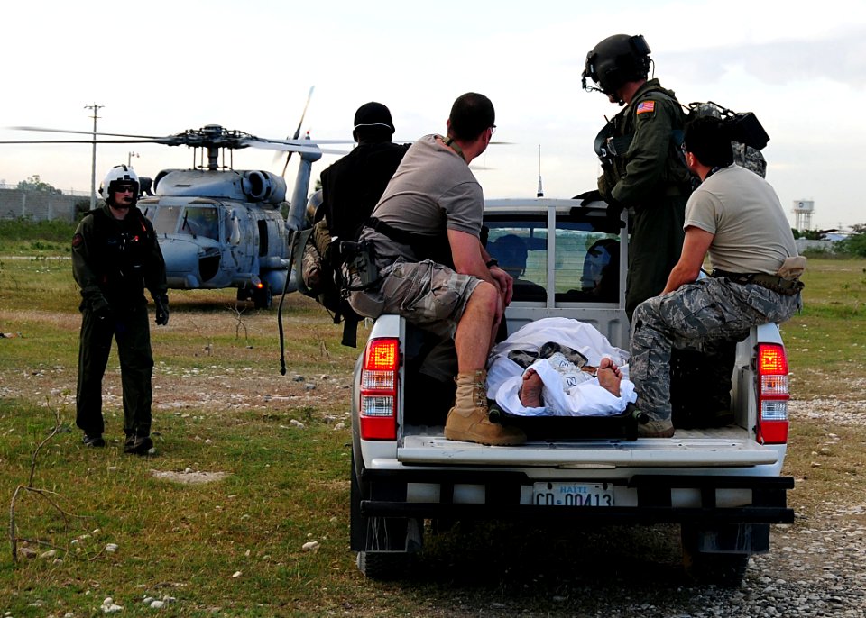 US Navy 100116-N-6247V-207 U.S. Navy Sailors assist U.S. Air Force airmen in transporting an earthquake victim to a helicopter during a medical evacuation in Port-au-Prince, Haiti, Jan. 16