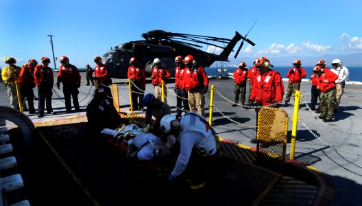 US Navy 100115-N-2953W-926 Sailors deliver an injured American citizen to USS Carl Vinson's (CVN 70) Health Services department for medical care
