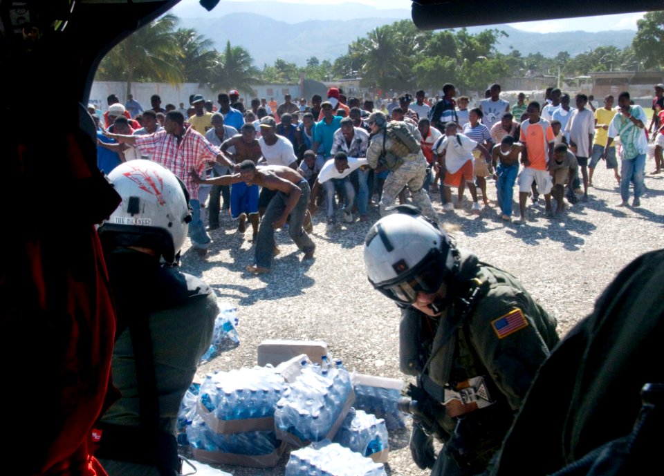 US Navy 100116-N-6006S-054 Haitian citizens receive water from air crewmen from Helicopter Sea Combat Squadron (HSC) 9 assigned to the aircraft carrier USS Carl Vinson (CVN 70)