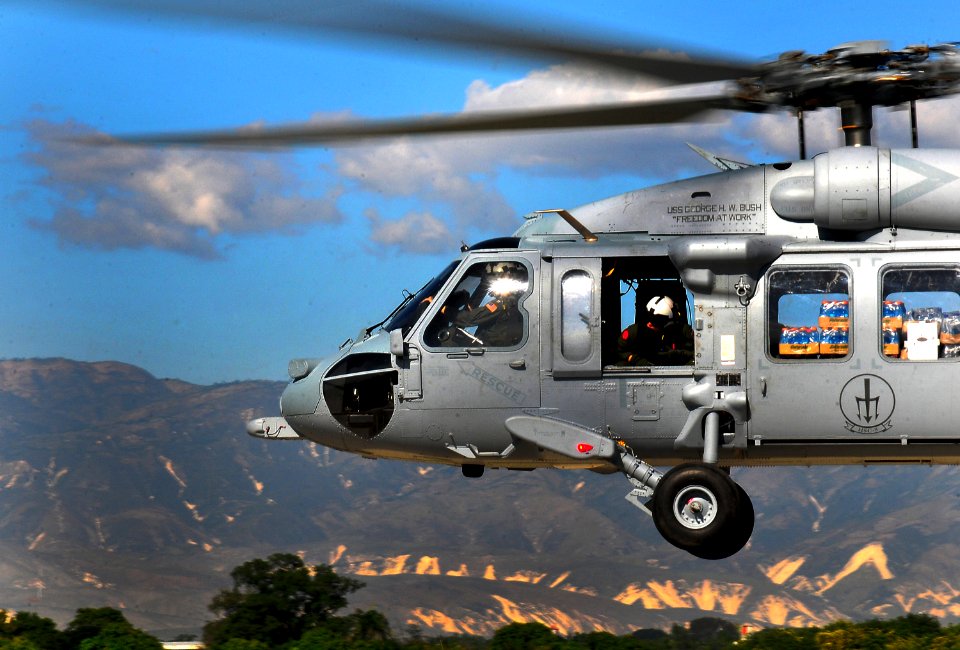 US Navy 100115-N-4774B-969 A SH-60F Sea Hawk helicopter assigned to the Red Lions of Helicopter Anti-Submarine Squadron (HS) 15, delivers water and supplies to Haiti as part of rescue and relief efforts