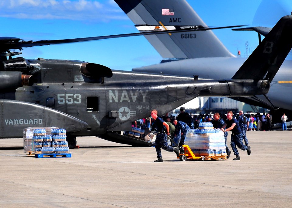 US Navy 100116-N-4774B-827 Sailors load bottles of fresh water into an MH-53E from Helicopter Mine Countermeasures Squadron (HM) 14 that will be delivered to earthquake survivors