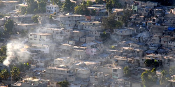US Navy 100115-N-6247V-153 Smoke billows from damaged Haitian homes and businesses following a 7.0 earthquake disaster on Jan. 12