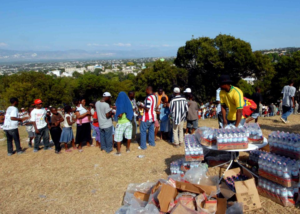 US Navy 100117-N-6639M-099 Haitian citizens that were affected by the 7.0 magnitude earthquake on Jan. 12, 2010 stand in line to receive bottled