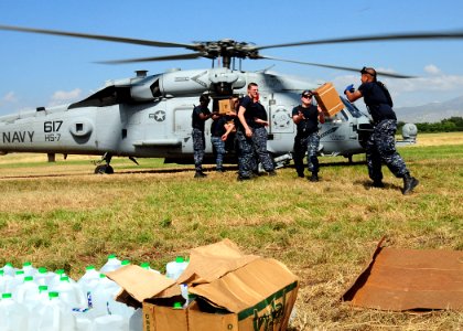 US Navy 100117-N-6247V-029 Sailors attached to the aircraft carrier USS Carl Vinson (CVN 70) load water and boxes of meals ready-to-eat (MREs) onto a SH-60S Sea Hawk helicopter of Helicopter Anti-submarine Squadron (HS) 7