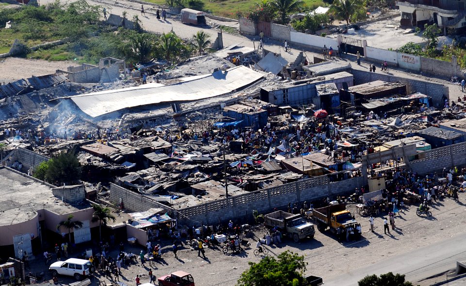 US Navy 100115-N-6247V-495 Haitian citizens gather in a severely damaged compound in Port-Au-Prince, Haiti, three days after the country suffered a 7.0 earthquake disaster on Jan. 12