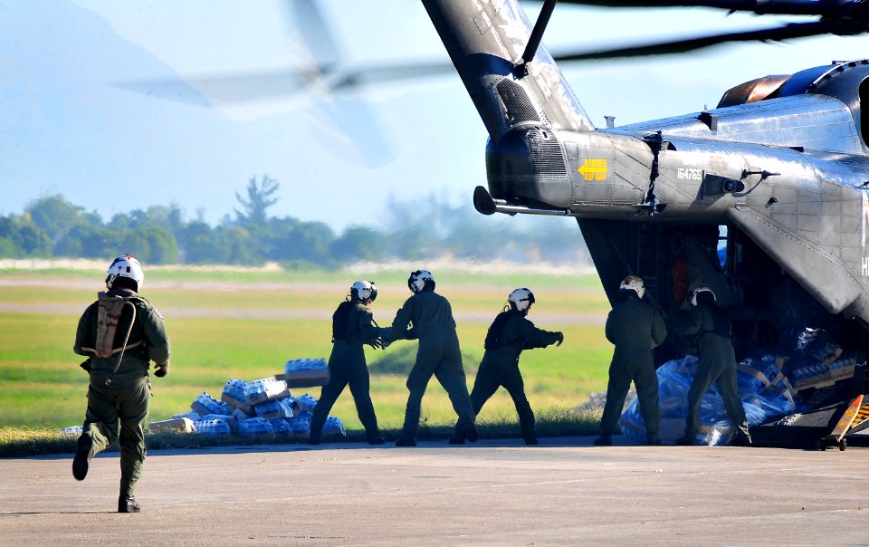 US Navy 100115-N-4774B-506 The crew of a U.S. Navy MH-53E Sea Dragon helicopter from the aircraft carrier USS Carl Vinson (CVN 70) unload food and supplies at the airport in Port-au-Prince, Haiti