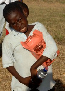 US Navy 100117-N-6639M-135 A Haitian boy receives his meal-ready-to eat and bottled water by U.S. military members in Port-au-Prince