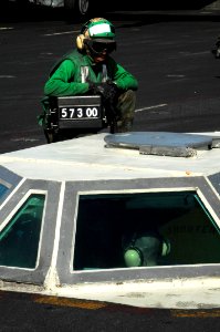 US Navy 100118-N-3038W-368 Weight board operator Aviation Boatswain's Mate (Equipment) Airman Recruit Matthew Baxter shows the weight board to watch standers inside the Integrated Catapult Control Station