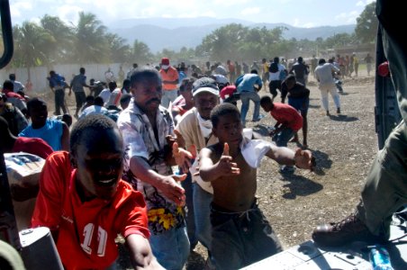 US Navy 100116-N-6006S-063 Haitian citizens receive water from U.S. Navy air crewmen from Helicopter Sea Combat Squadron (HSC) 9, assigned to the aircraft carrier USS Carl Vinson (CVN 70) photo