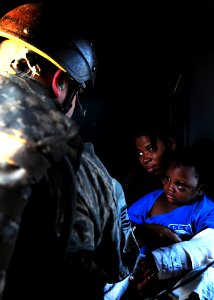 US Navy 100116-N-6247V-269 An air crewman comforts Haitian earthquake victims during a medical evacuation aboard an U.S. Navy SH-60F Sea Hawk assigned to the Red Lions of Anti-submarine Squadron (HS) 15