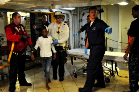 US Navy 100116-N-4774B-884 Aboard USS Carl Vinson (CVN 70) medical team members assist an injured Haitian child for treatment aboard the nuclear-powered aircraft carrier