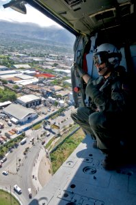 US Navy 100116-N-6006S-081 An aircrew chief from Helicopter Sea Combat Squadron (HSC) 9, surveys the city of Port-au-Prince before landing photo