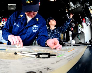 US Navy 100116-N-7508R-005 Quartermaster 1st Class David Mitchell plots the course aboard multi-purpose amphibious assault ship USS Bataan (LHD 5) as they pull away from the pier photo
