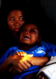 US Navy 100116-N-6247V-286 A young Haitian earthquake victim is comforted by her older sister during a medical evacuation aboard an U.S. Navy SH-60F Sea Hawk
