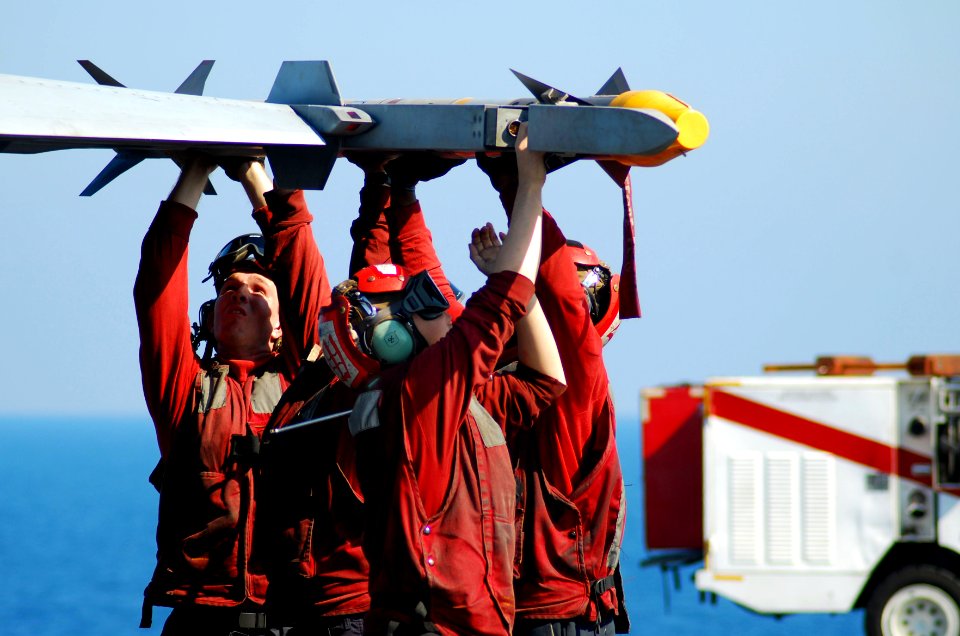 US Navy 100118-N-3589B-046 Sailors load ordnance to the wing of an F-A-18C Hornet assigned to the Sidewinders of Strike Fighter Squadron (VFA) 86