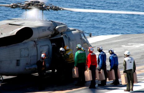 US Navy 100118-N-8822R-041 Sailors load water jugs onto an SH-60F Sea Hawk helicopter to be delivered to Haiti