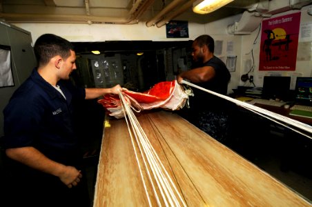 US Navy 100119-N-3038W-116 ailors perform maintenance on a parachute aboard the aircraft carrier USS Nimitz (CVN 68)