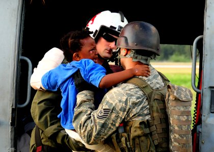 US Navy 100116-N-6247V-291 Naval Air Crewman 2nd Class Jason Harold of Goldsboro, N.C., transfers a young Haitian earthquake victim from an SH-60B Seahawk helicopter