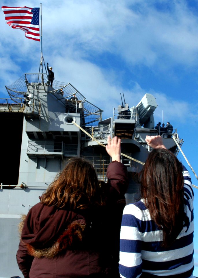 US Navy 100118-N-6764G-076 Family members of Lt. Scott Moak, the hangar bay officer aboard the amphibious assault ship USS Nassau (LHA 4), wave goodbye as Nassau pulls away from the pier