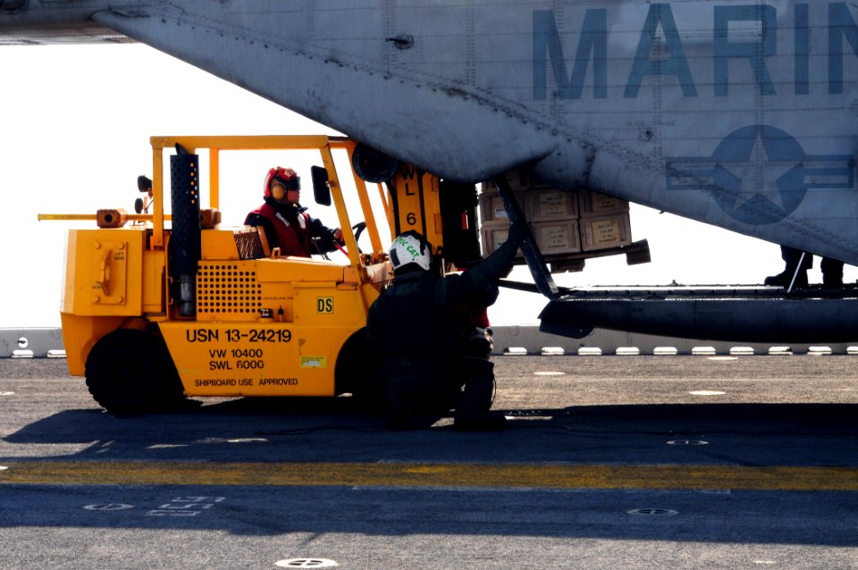 US Navy 100116-N-7508R-031 Sailors aboard the multi-purpose amphibious assault ship USS Bataan (LHD 5) load supplies after getting underway from Morehead City, N.C