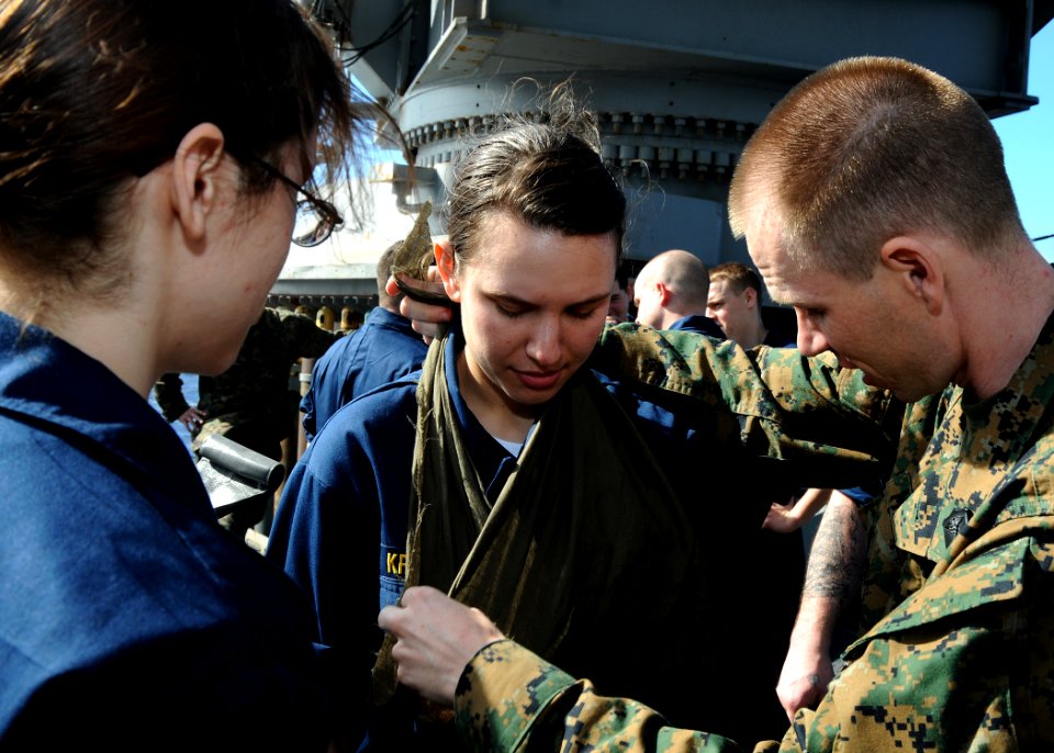 US Navy 100117-N-7948C-023 Hospital Corpsman 1st Class Dennis Minydzak, from Pittsburgh, demonstrates on Ensign Whitney Krese the proper method for applying a sling during basic life-saving and preventive medicine training aboa