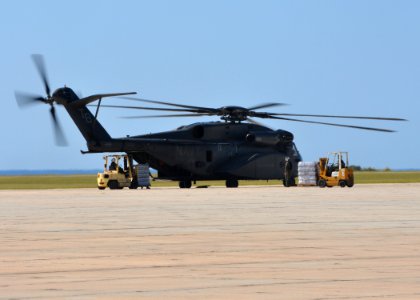 US Navy 100118-N-8241M-112 Sailors assigned to the Naval Station Guantanamo Bay Cuba supply department load disaster relief supplies on an MH-53E Sea Dragon helicopter