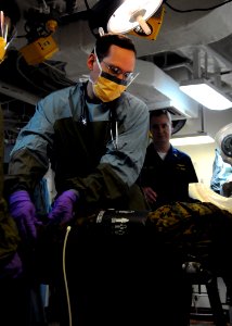 US Navy 100117-N-3165S-132 t. Craig Fossee practices examining a patient aboard the multi-purpose amphibious assault ship USS Bataan (LHD 5) during a mass casualty drill to prepare for patients from Haiti photo