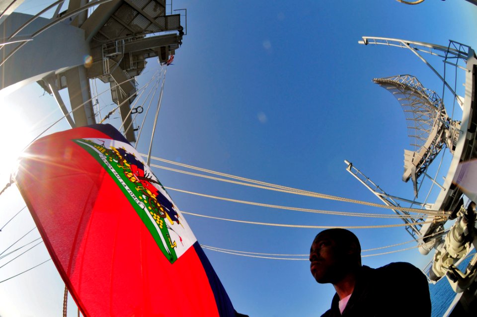 US Navy 100117-N-6006S-095 Quartermaster Seaman Rinzy Braxton hoists Haiti's national flag in honor of the Haitian people as the ship continues its mission in Operation Unified Support