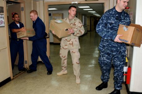 US Navy 100117-N-6410J-003 Hospital corpsmen load medical supplies into the pharmacy storage room aboard the Military Sealift Command hospital ship USNS Comfort (T-AH 20) in preparation to support Operation Unified Response photo