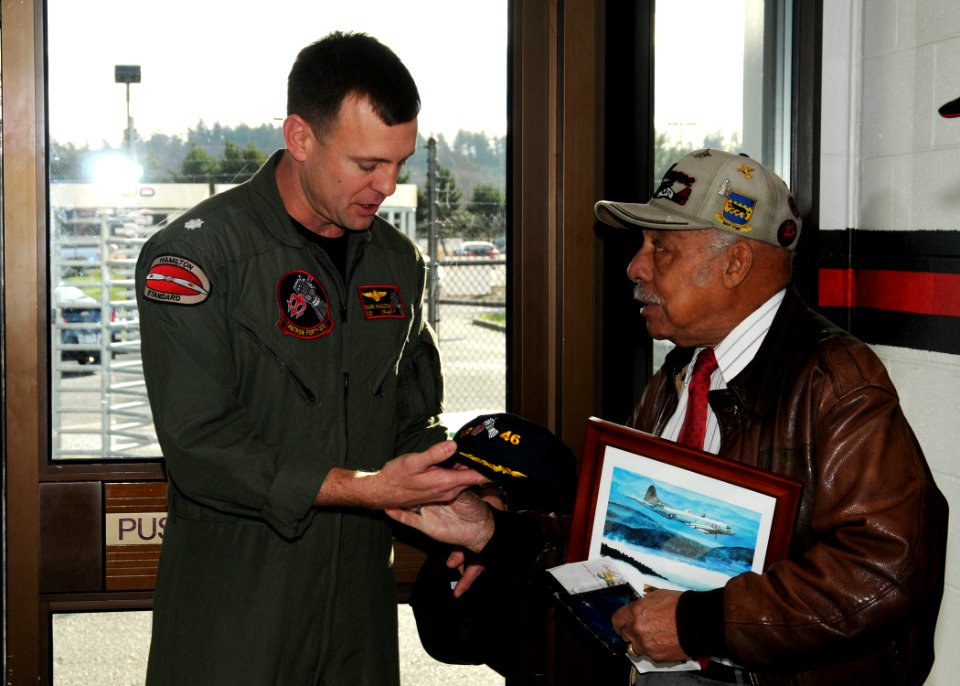 US Navy 100116-N-9860Y-003 Cmdr. Mark Hamilton, commanding officer of the Grey Knights of Patrol Squadron (VP) 46, presents a command photo and ball cap to retired U.S. Air Force Lt. Col. William Holloman III