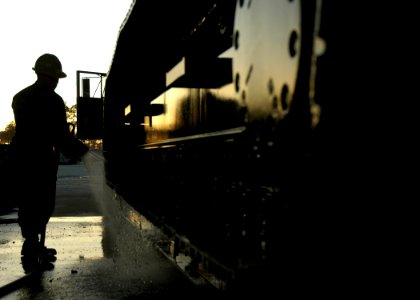 US Navy 100118-N-7367K-001 Equipment Operator 3rd Class Jose Carrasquillo, a Seabee assigned to Naval Mobile Construction Battalion (NMCB) 7, washes an excavator before shipment to Haiti photo