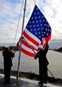 US Navy 100118-N-1082Z-009 Sailors lower the national ensign aboard the amphibious dock landing ship USS Ashland (LSD 48