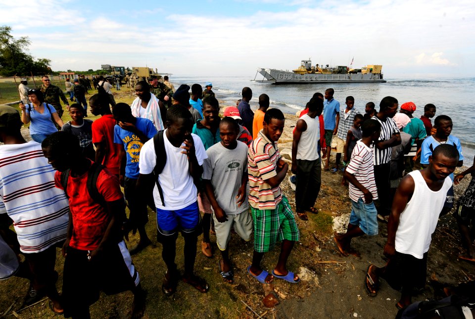 US Navy 100119-N-5345W-042 Haitian citizens watch as Sailors and Marines assigned to the Bataan Amphibious Relief Mission begin to come ashore to set up an operating base at the New Hope Mission at Bonel, Haiti