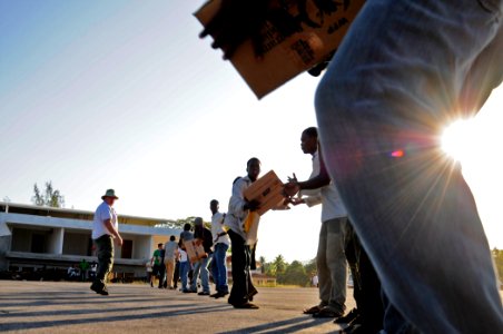 US Navy 100118-N-6006S-001 United Nations volunteers and Haitian citizens unload supplies delivered by a helicopter assigned to Helicopter Sea Combat Squadron (HSC) 26 embarked aboard the aircraft carrier USS Carl Vinson (CVN 7